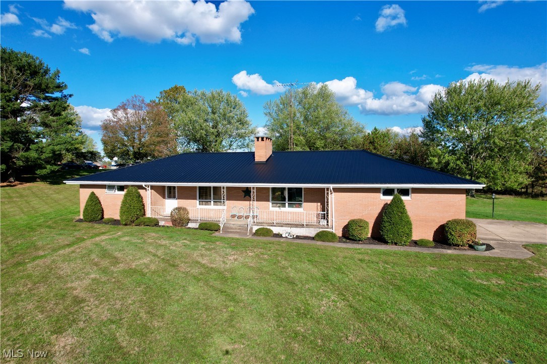 248 Scio Road Carrollton, OH 44615 - Photo 1 of 33 Ranch-style home featuring a porch, a front yard, brick siding, a chimney, and a metal roof