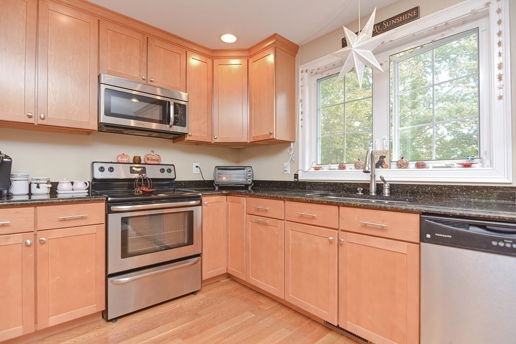 115 Bruce Road Walpole, MA 02081 - Photo 14 of 42 a kitchen with stainless steel appliances granite countertop a sink a microwave and cabinets