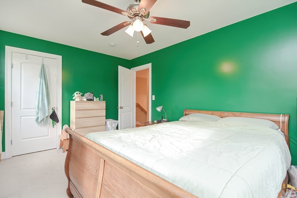 115 Bruce Road Walpole, MA 02081 - Photo 27 of 42 a spacious bedroom with a large bed and a chandelier