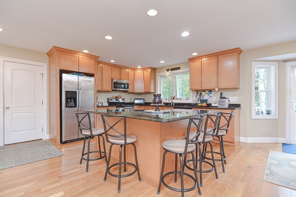 115 Bruce Road Walpole, MA 02081 - Photo 10 of 42 a kitchen with stainless steel appliances kitchen island granite countertop a refrigerator and a stove top oven