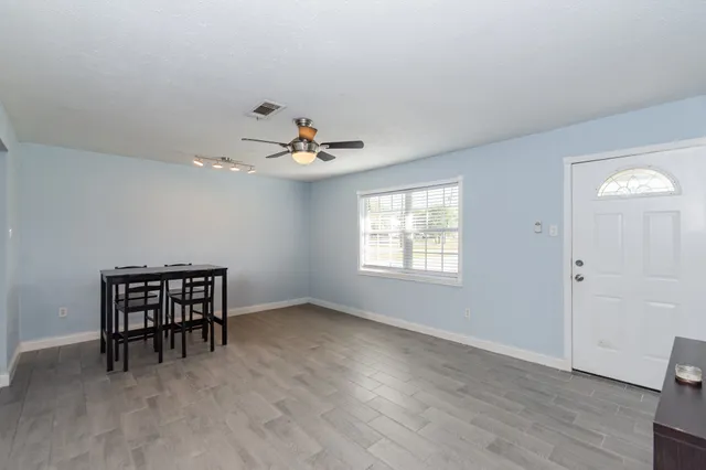 a view of work space with windows and chandelier fan