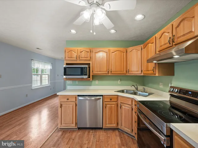 a kitchen with stainless steel appliances granite countertop a stove sink and refrigerator