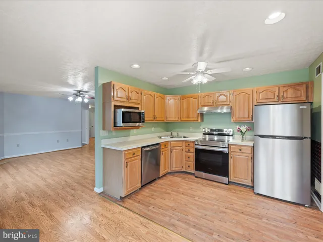 an empty room with wooden floor fireplace and windows