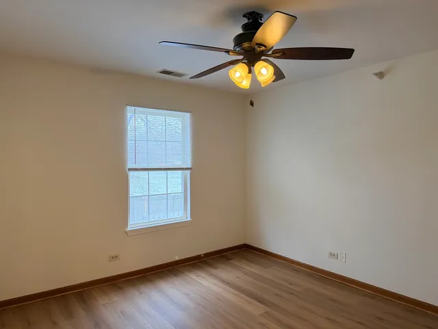 an empty room with a window and wooden floor