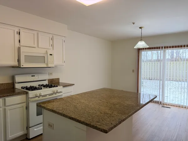 a kitchen with granite countertop a sink cabinets and window