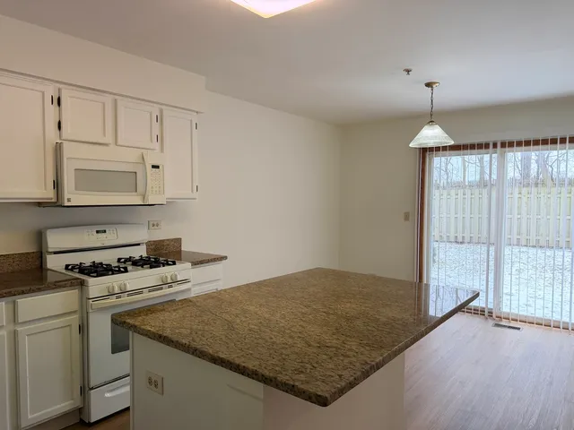 a kitchen with granite countertop a sink cabinets and window