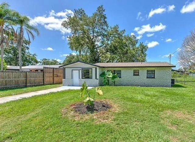 a view of a yard in front of a house with large trees