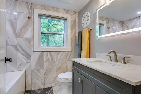 a bathroom with a sink a toilet and a window