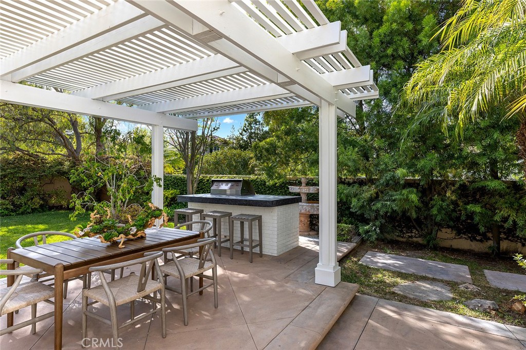 16 Meryton Irvine, CA 92603 - Photo 46 of 54 a view of a patio with table and chairs potted plants with wooden floor and fence