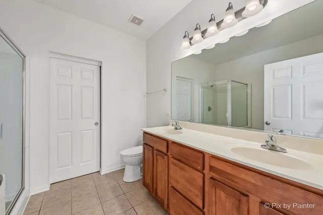 a spacious bathroom with a granite countertop sink a toilet and a mirror