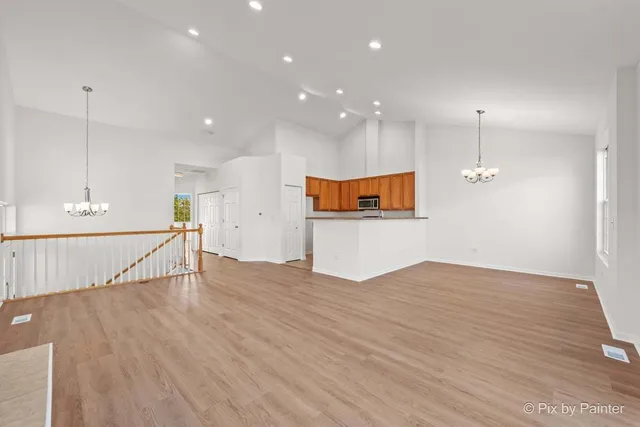 a view of empty room with wooden floor and window
