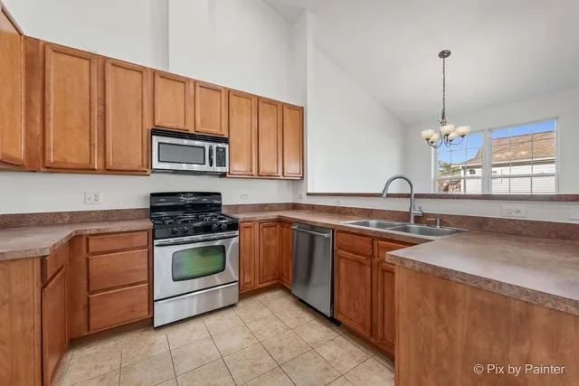 a kitchen with stainless steel appliances granite countertop a sink a stove a microwave and cabinets