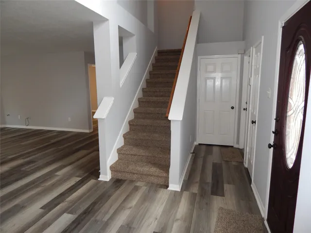 a view of a hallway view with wooden floor and staircase