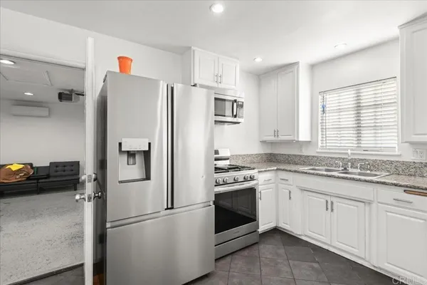 a kitchen with stainless steel appliances granite countertop a refrigerator sink and cabinets