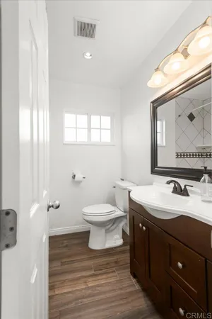 a bathroom with a toilet sink and mirror