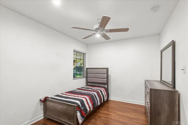 a bedroom with a bed and a ceiling fan
