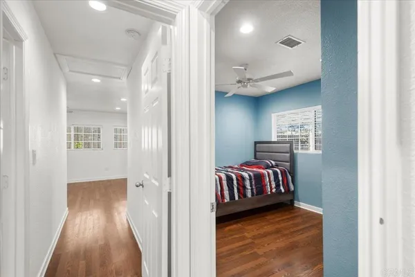 a view of a hallway with entryway wooden floor and cabinet