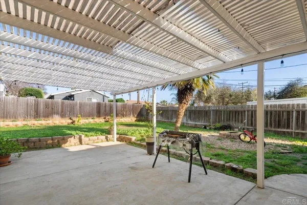 a view of a backyard with table and chairs under an umbrella with a small yard