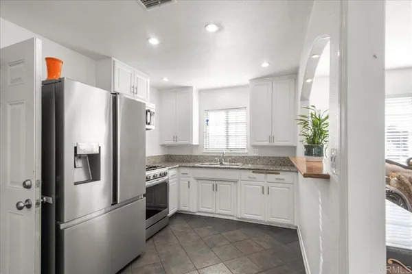 a kitchen with stainless steel appliances granite countertop a refrigerator and a sink