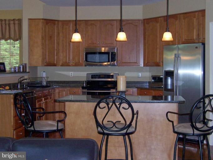 5957 Sandy Ridge Elkridge, MD 21075 - Photo 7 of 30 a kitchen with stainless steel appliances a stove a refrigerator and cabinets