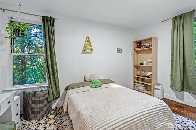 a bedroom with a bed and wooden floor