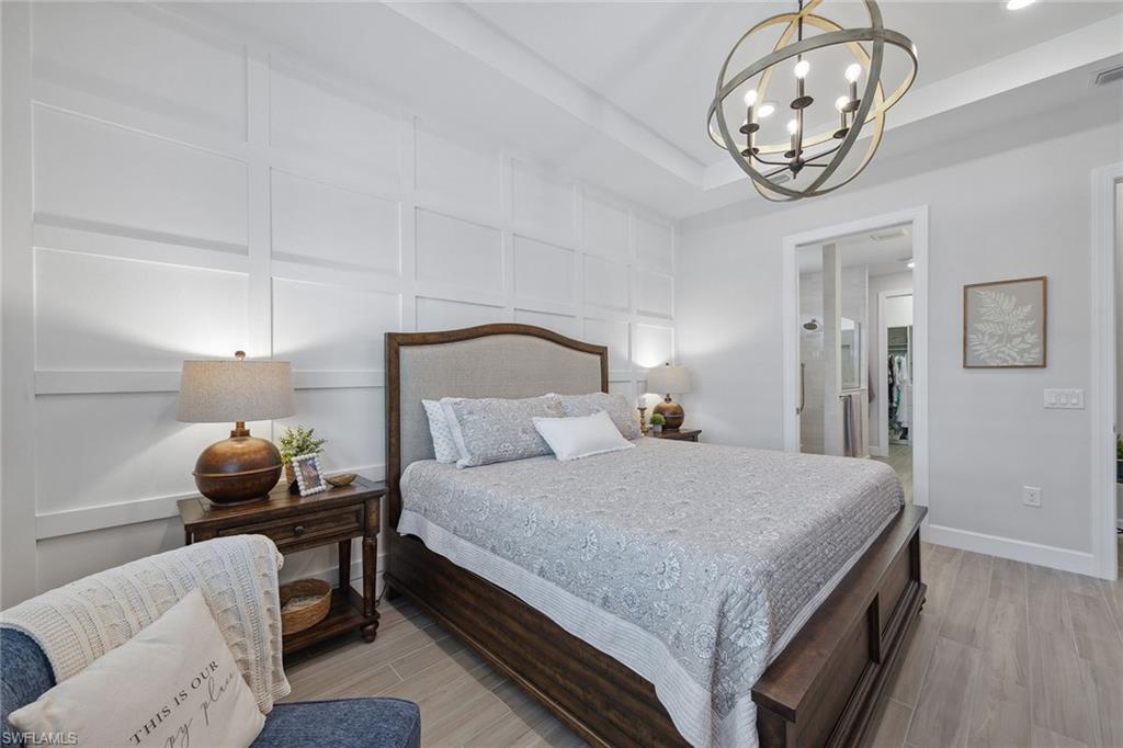 2703 Aviamar Circle Naples, FL 34114 - Photo 17 of 49 a bedroom with a bed and chandelier