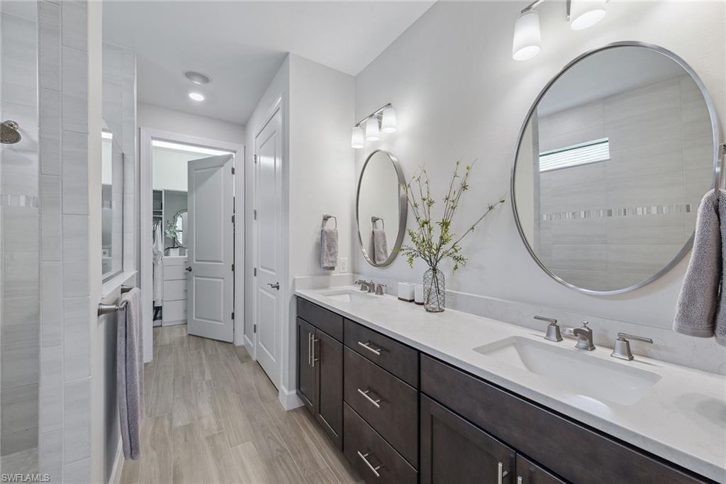 2703 Aviamar Circle Naples, FL 34114 - Photo 19 of 49 a en suite bathroom with a double vanity sink and a mirror