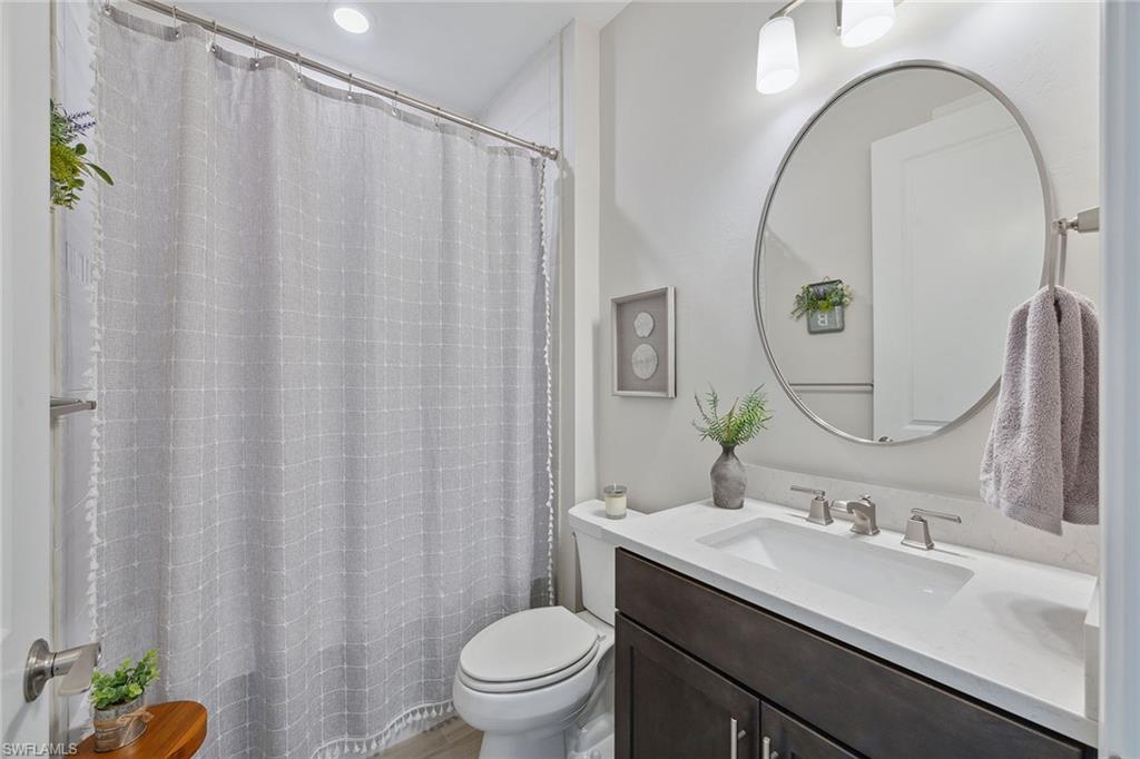 2703 Aviamar Circle Naples, FL 34114 - Photo 25 of 49 a bathroom with a granite countertop sink a toilet and a mirror