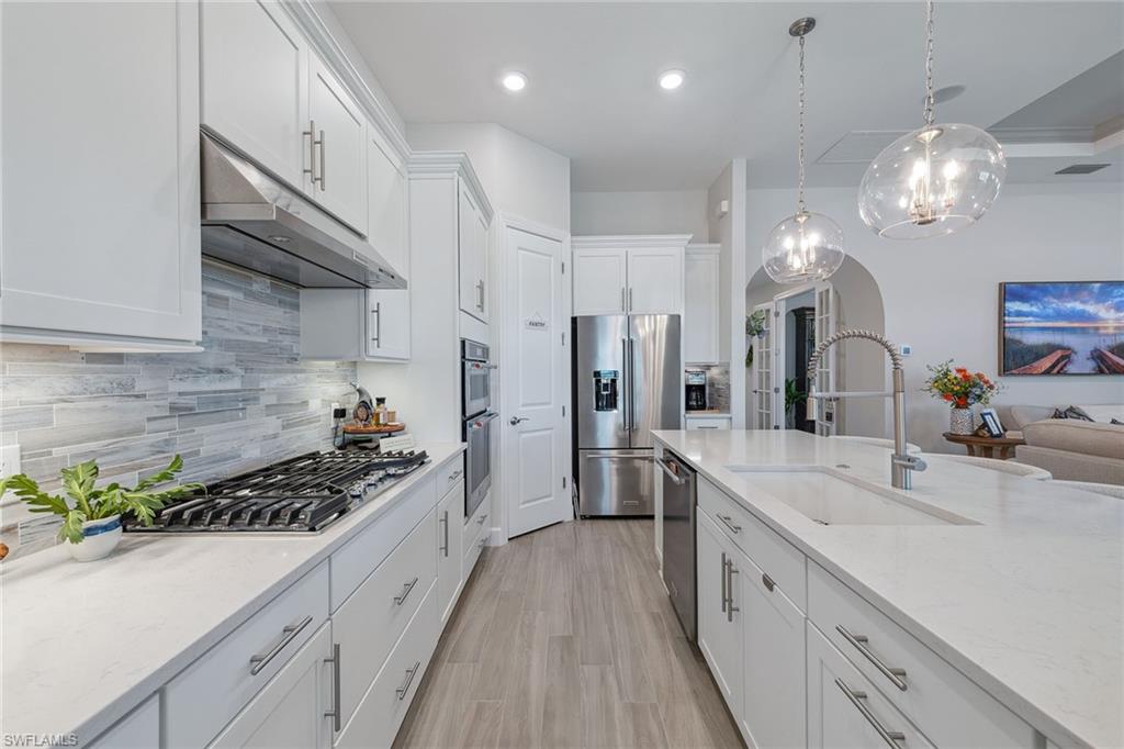 2703 Aviamar Circle Naples, FL 34114 - Photo 3 of 49 a large kitchen with stainless steel appliances a lot of counter space and wooden floor