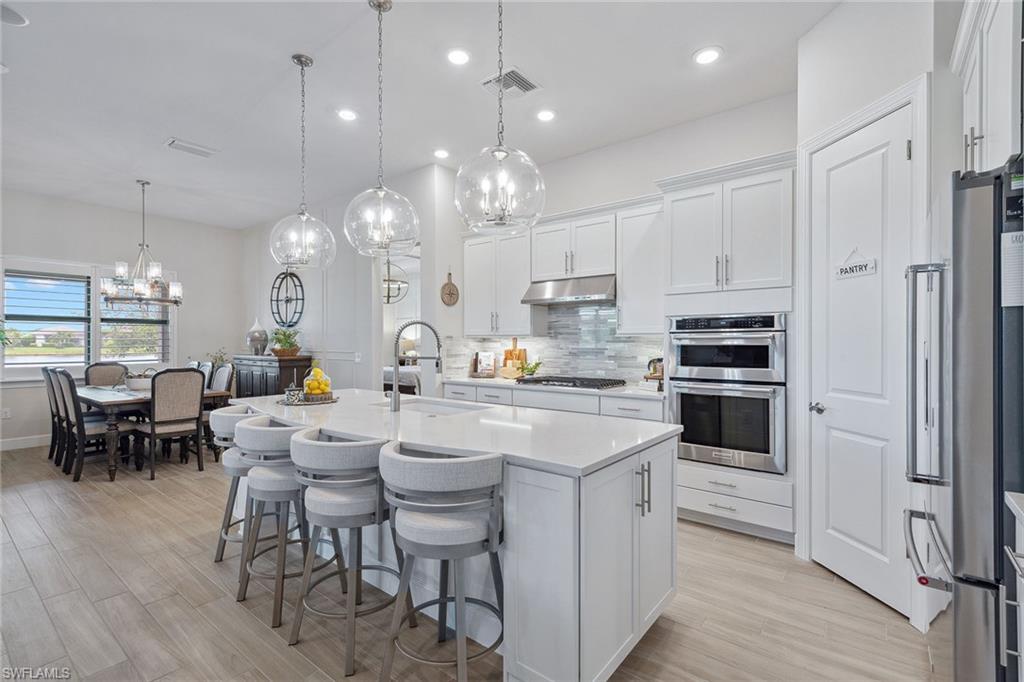 2703 Aviamar Circle Naples, FL 34114 - Photo 9 of 49 a large white kitchen with stainless steel appliances