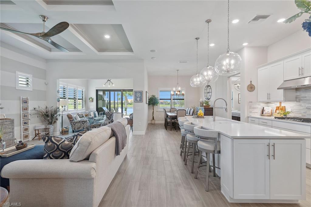 2703 Aviamar Circle Naples, FL 34114 - Photo 10 of 49 a living room with furniture kitchen view and a wooden floor
