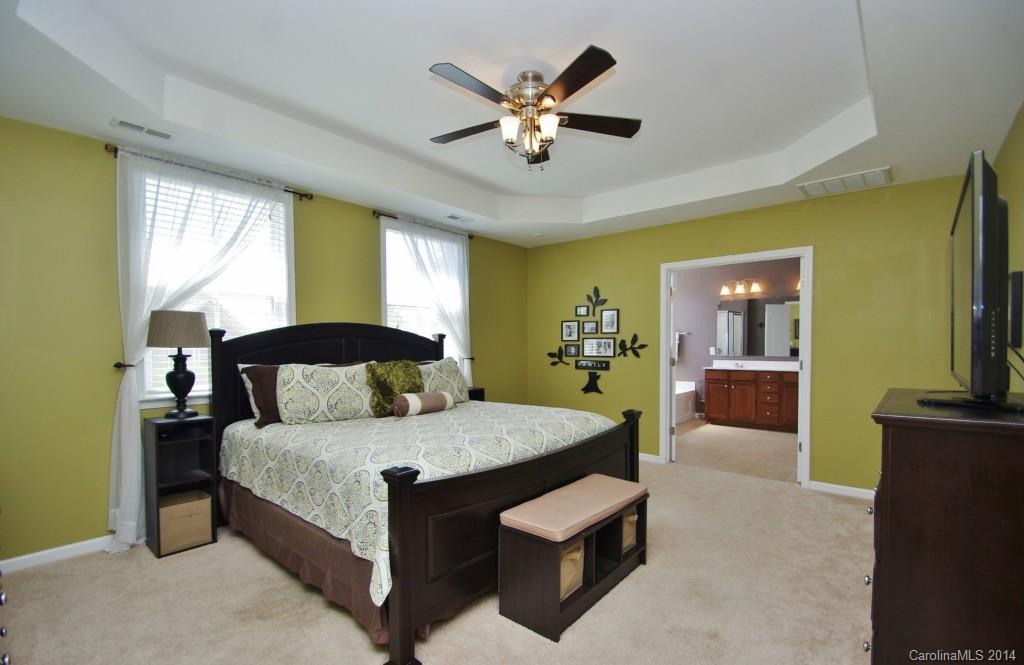 1301 Ridgehaven Road Waxhaw, NC 28173 - Photo 12 of 24 a bedroom with a large bed and a chandelier