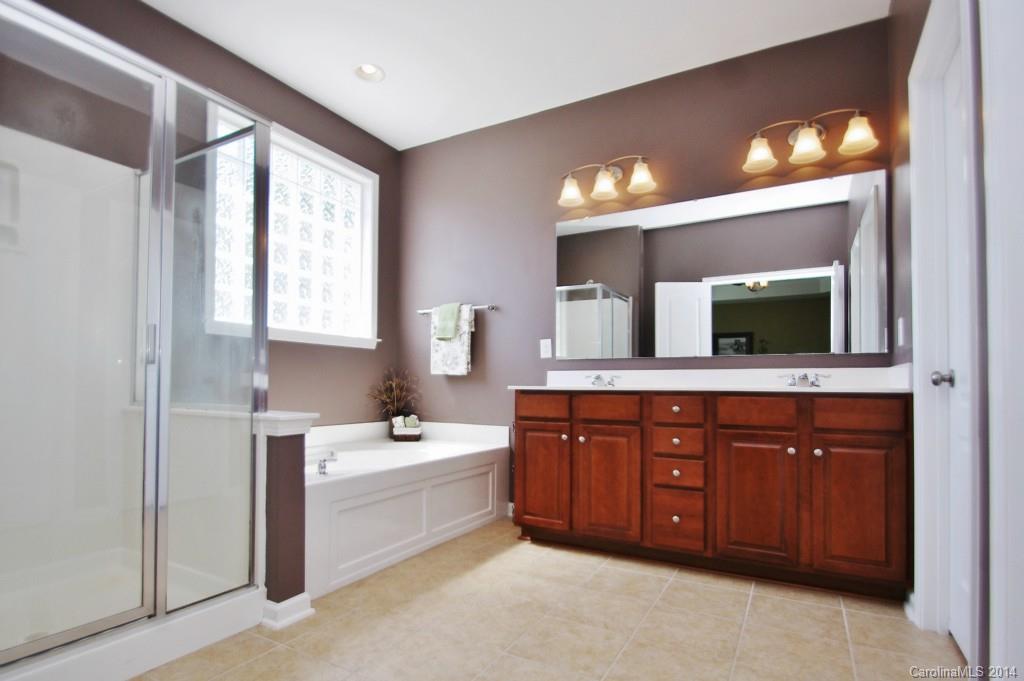 1301 Ridgehaven Road Waxhaw, NC 28173 - Photo 13 of 24 a spacious bathroom with a double vanity sink a large mirror and a bathtub
