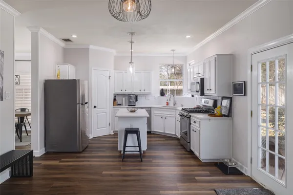 a kitchen with white cabinets and stainless steel appliances