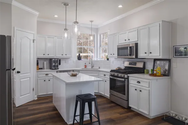 a kitchen with white cabinets stainless steel appliances and sink