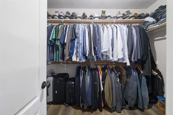 a view of walk in closet with clothes