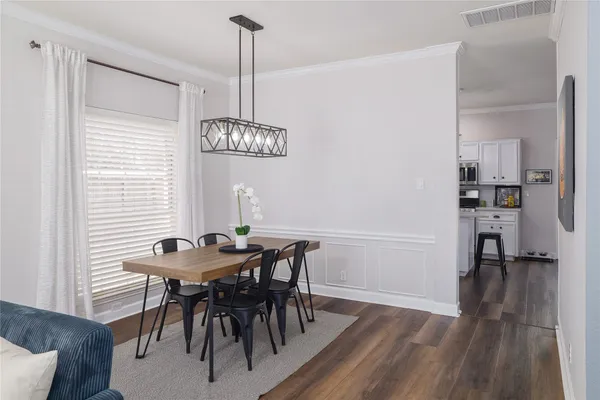 a view of a dining room with furniture wooden floor and a chandelier