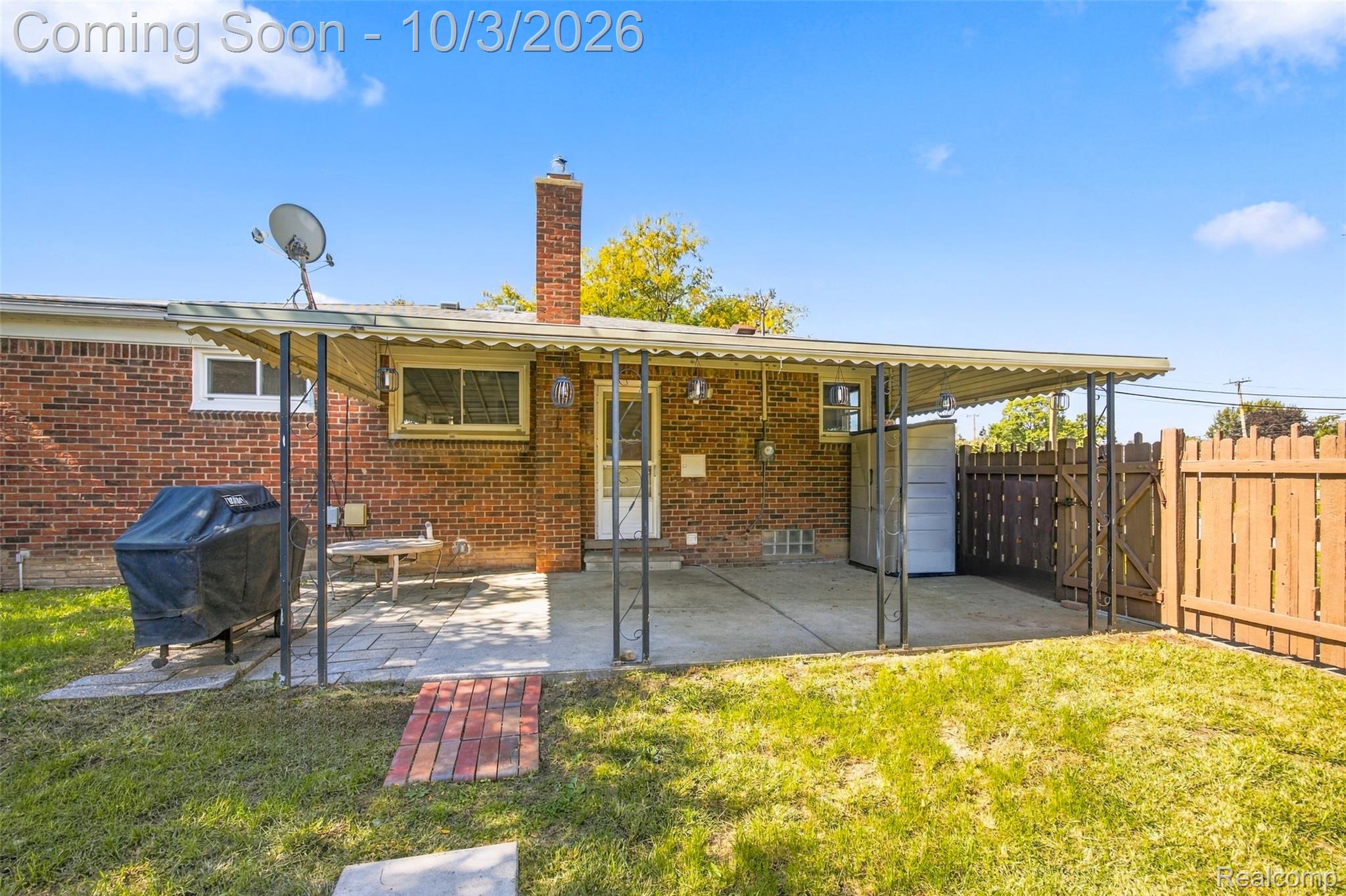 556 Henry Ruff Road Garden City, MI 48135 - Photo 32 of 49 Brick exterior with a covered patio, concrete and paver hardscaping, mature lawn, and a privacy fence