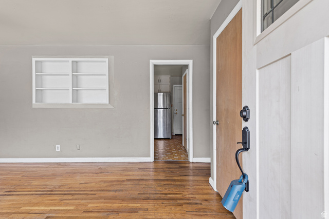 542 East 3400th Street North Provo, UT 84604 - Photo 8 of 39 Entryway featuring a white paneled door with black hardware, wood-finish flooring, light gray walls, and a recessed built-in shelving unit