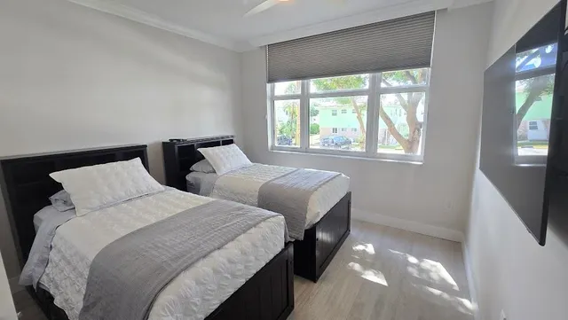 a bedroom with two beds and a large window