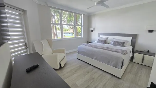 a bedroom with a bed and a large window
