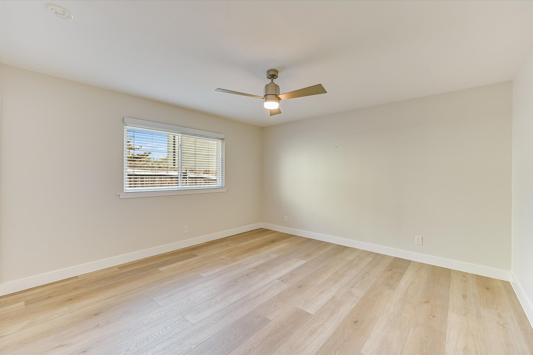 1201 Dailey Street Austin, TX 78703 - Photo 12 of 14 an empty room with wooden floor ceiling fan and windows