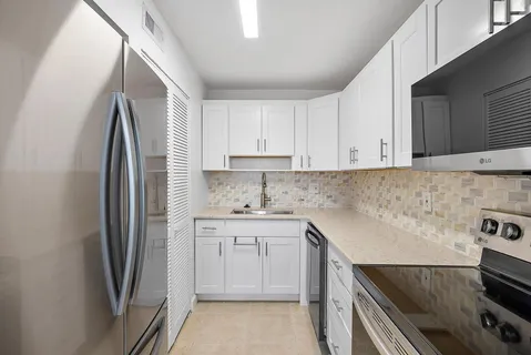 a kitchen with stainless steel appliances granite countertop a refrigerator sink and stove