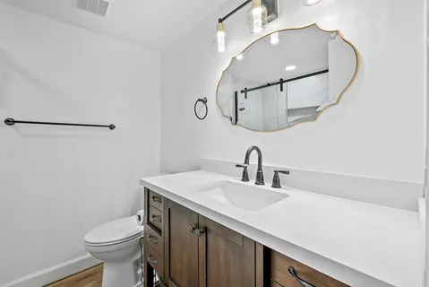 a bathroom with a sink vanity mirror and toilet