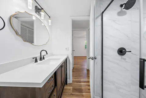 a bathroom with a double vanity sink a mirror and shower