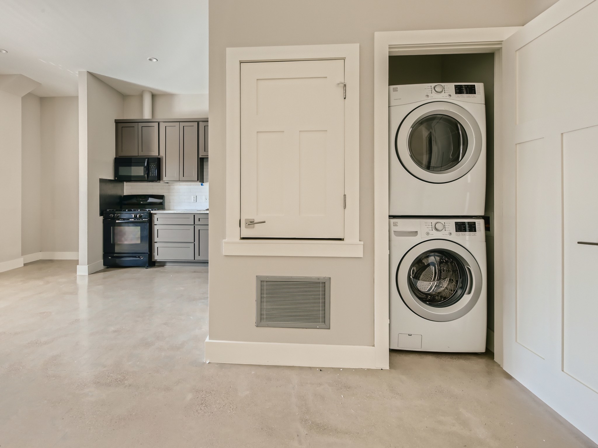 3523 Gonzalez Street, Unit 200 Austin, TX 78702 - Photo 10 of 10 Stacked washer and dryer unit in a dedicated alcove, complemented by light grey flooring