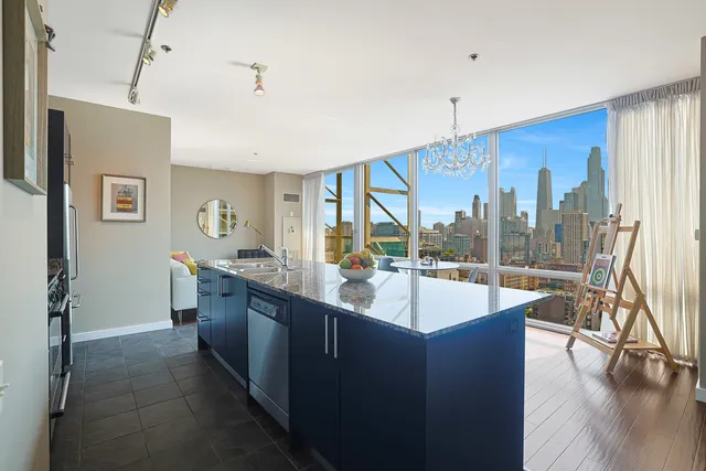 a kitchen with granite countertop a sink a stove and a refrigerator