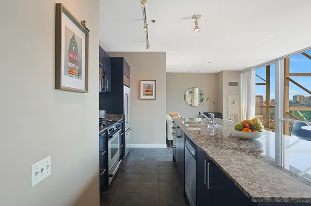 a kitchen with stainless steel appliances a dining table chairs and wooden floor