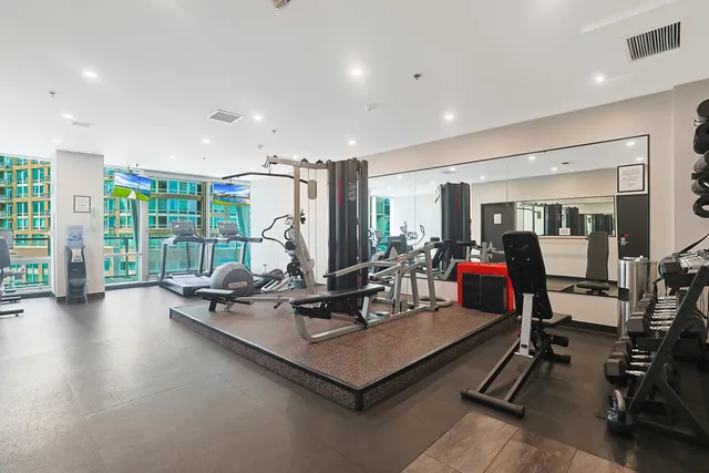 a view of a lake with a bench and trees in the background
