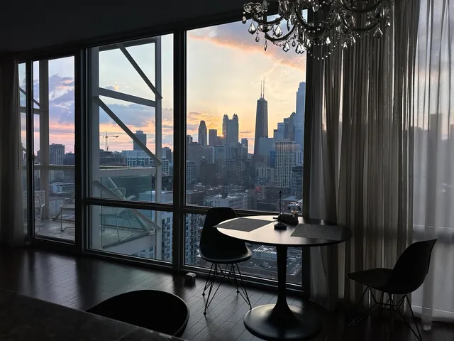 a view of a balcony with two chairs and a potted plant